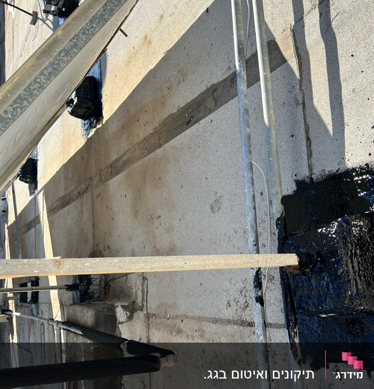 איטום גג עם זפת שחורה סביב עמודים